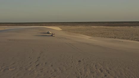 Offroad-vehicles-explore-windy-Brazil-dunes-with-sand-gusts-in-sunset