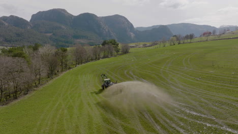 Tractor-on-scenic-farm-spraying-organic-fertilizer-on-pasture