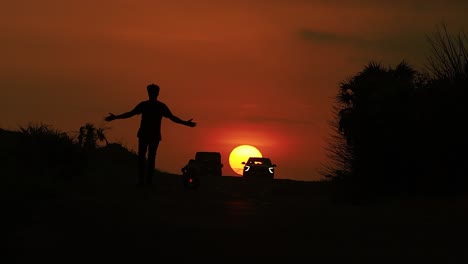 Low-angle-shot-of-man-walking-in-the-street-with-sunset-view-in-the-background-at-Diu-city-of-Inida