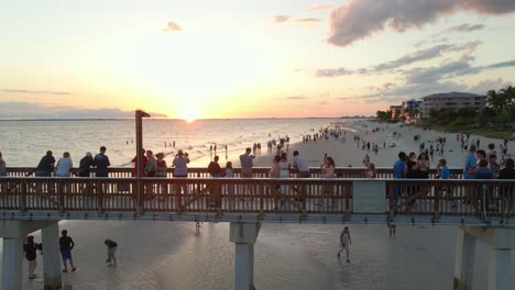 People-crowded-on-Fort-Myers-beach-Pier-looking-at-a-beautiful-sunset-over-the-ocean