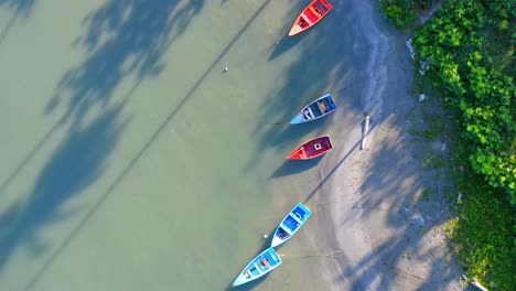 Aerial-top-down-forward-over-colorful-boats-at-Soco-river-mouth,-Dominican-Republic