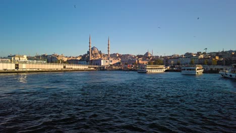 View-from-a-boat-of-Eminonu-Harbor-in-Bosphorus,-Istanbul,-Turkey-with-a-train-view-of-a-train-in-the-foreground-and-a-mosque-in-the-background