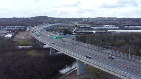 Traffic-vehicles-moving-across-busy-suspension-bridge-highway-landmark-aerial-rising-view
