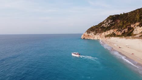 Taxi-Boat-transport-Tourist-People-from-Milos-Beach-to-Agios-Nikitas-at-Lefkada-Island,-Greece---Aerial