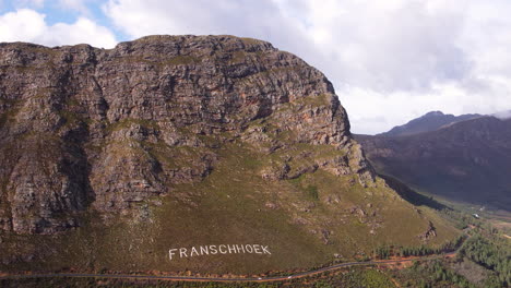 Aerial-arc-shows-scenic-route-of-Franschhoek-mountain-pass,-South-Africa