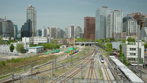 KTX-Train-Arrives-at-Seoul-Station,-Cityscape-Skyline-Panorama-Against-Blue-Sky