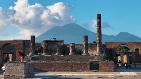 Wide-shot-showing-tourist-visiting-famous-old-ruin-of-Pompeii-with-epic-Mount-Vesuvius-in-background