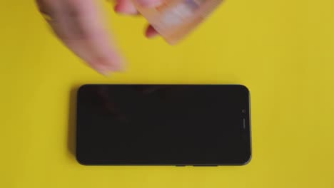 Verkauf-Eines-Teuren-Telefons,-Um-Vor-Gelbem-Hintergrund-über-Die-Runden-Zu-Kommen