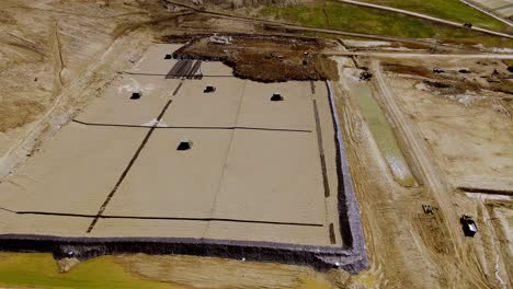 Heavy-equipment-preparing-foundation-for-a-landfill,-aerial-drone-view