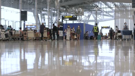 POV-Im-Abflugterminal-Des-Flughafens-Suvannabhumi-Mit-Vielen-Passagieren,-Die-Während-Des-Covid-Ausbruchs-Spazieren-Gehen