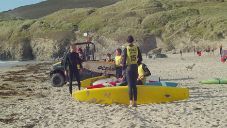 Teenagers-Prepare-with-their-Surf-Boards-to-Run-into-the-Sea-with-Instruction-by-their-Teacher-at-Perranporth-in-Cornwall