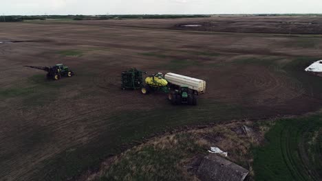 Drone-orbiting-shot-preparing-to-seed-a-field-with-John-Deere-tractor