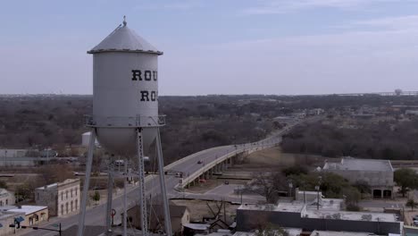 Static-aerial-shot-of-Round-Rock-water-tower-in-Round-Rock,-Texas-with-Main-Street-in-the-background