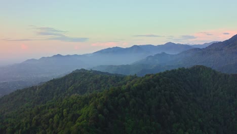 Drone-view-of-forest-hill-ranges-and-foggy-valleys-at-evening-dawn