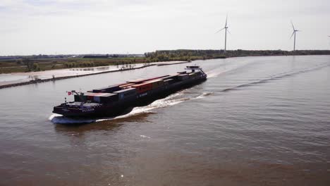 Aerial-Circle-Dolly-Around-Forward-Bow-Of-Petran-Cargo-Ship-Along-Oude-Maas