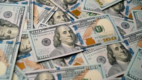 Stack-of-100-dollar-Benjamin-Franklin-bills-tilt-shot-focusing