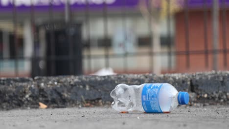 Empty-plastic-bottle-thrown-on-ground-on-city-street
