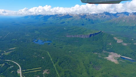 Small-airplane-flying-over-the-Matanuska-River-near-the-town-of-Palmer-with-the-Talkeetna-Range-of-Alaska-in-the-distance