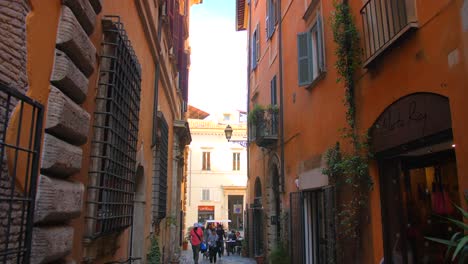 Edificios-Imponentes-Con-Gente-Caminando-Por-Calles-Estrechas-Cerca-De-La-Fuente-De-La-Tortuga-En-Roma,-Italia