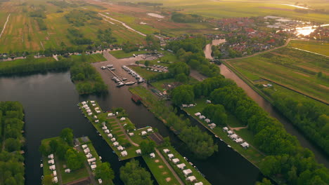 Luftaufnahme-Einer-Ländlichen-Niederländischen-Landschaft-Mit-Grünen-Feldern,-Häusern,-Booten-Und-Poldern-In-Waterstaete-Ossenzijl,-Niederlande