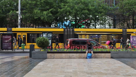 Yellow-commuter-tram-pulls-out-of-square-in-front-of-Nyugati-Station,-Budapest