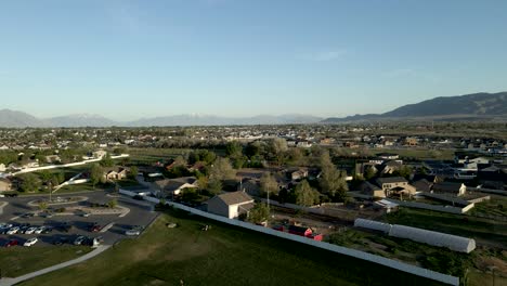 A-suburban-community-next-to-a-park-with-mountains-in-the-distance---aerial-flyover