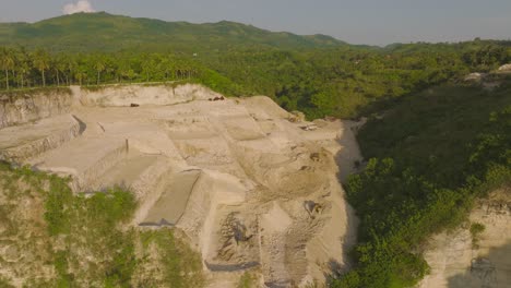 Quarry-open-pit-excavation-site-on-mountainous-cliffs-of-Nusa-Penida,-aerial