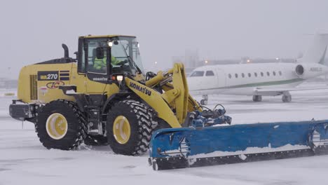 Am-Traktor-Befestigter-Schneepflug-Räumt-Schnee-Von-Der-Straße-Am-Flughafen