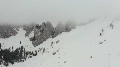 Aerial-of-snow-covered-mountain-peaks-in-thick-mist
