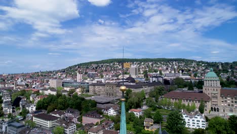 Aerial-orbit-around-church-spire-in-Zurich-with-panoramic-view-of-city