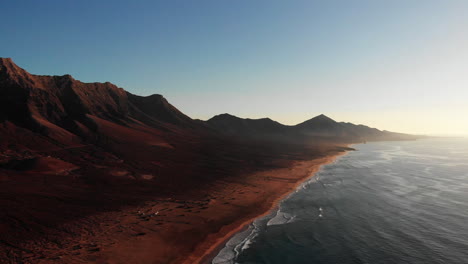 Vista-Aérea-De-Drones-De-La-Hermosa-Playa-De-Fuerteventura-Con-Un-Horizonte-Interminable-Al-Atardecer