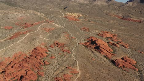 Aerial-view-of-sand-roads-and-red-sandstone-cliffs-in-sunny-USA---tilt,-drone-shot