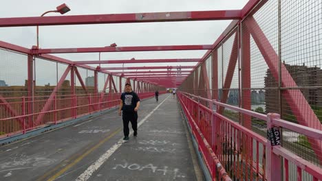People-Walking-and-Running-Over-Red-Bridge-in-Urban-City