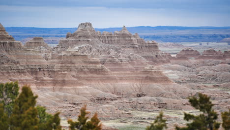 A-towering-peak-overlooking-Badlands-National-Park,-United-States,-with-some-foliage-in-the-lower-foreground