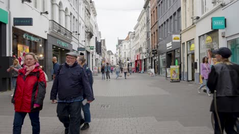 Crowd-of-people-walking-through-busy-shopping-street-Lange-Munt-in-Ghent,-Belgium