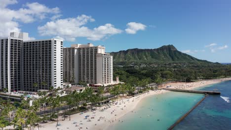 Wide-aerial-push-in-shot-of-the-Diamond-Head-volcanic-formation-from-Waikiki-Beach-on-the-island-of-O'ahu,-Hawaii