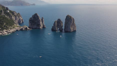 Famous-Italy-Travel-Destination:-Faraglioni-Rocks-on-Coast-of-Capri,-Island---Aerial