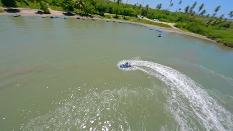 Aerial-drone-fpv-flying-around-jet-ski-over-Caribbean-sea-waters-at-Playa-Nueva-Romana-beach,-San-Pedro-de-Macoris-in-Dominican-Republic