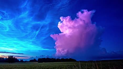 Low-angle-shot-of-blue-noctilucent-clouds-above-rural-agricultural-farmland-in-summer-during-evening-in-timelapse