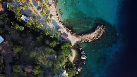 Dolly-in-overhead-aerial-view-of-the-shore-of-Blue-Bay-beach-in-Curacao,-Dutch-Caribbean-island