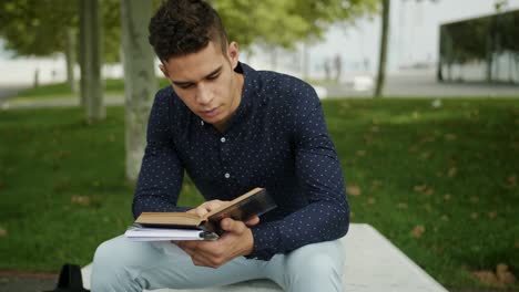Well-Dressed-Portrait-Young-Attractive-Trendy-Man-reading-an-old-book-a-urban-park-sunny-morning-day