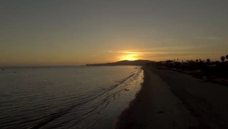 Drone-flying-over-Santa-Barbara-ocean-watching-vibrant-sunset