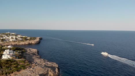 AERIAL:-Following-Boat-via-drone-close-the-coast-of-east-Mallorca,-Spain