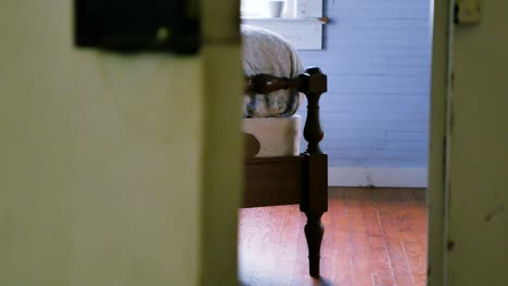 Smooth-left-to-right-dolly-shot-that-reveals-a-vintage-wooden-bed-being-bounced-and-shaking-suggestively-from-activity-on-the-bed