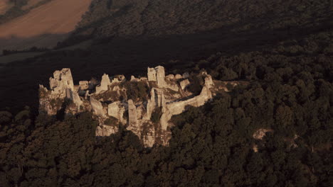 Aerial-shot-of-Gymes-Castle-ruins-lit-by-last-beams-of-sunset