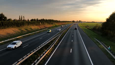 Autobahn-Mit-Fahrenden-Autos-Bei-Sonnenuntergang
