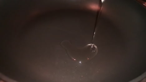 Slow-motion-of-oil-being-poured-down-a-frying-pan