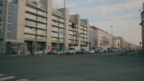 Kreuzung-Mit-Vielen-Kreuzenden-Fahrzeugen-Und-Autos,-Mitten-In-Wien,-Österreich,-In-Der-Nähe-Von-Häusern-Und-Gebäuden,-An-Einem-Sonnigen-Tag-Mit-Einigen-Wolken