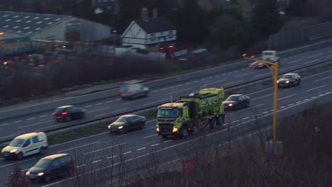 Aerial-pan-tilt-tracking-shot-of-busy-rush-hour-traffic-on-the-M20-motorway-in-Kent,-UK