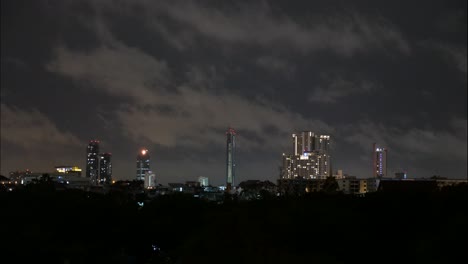 Timelapse-of-a-cloudy-sky-at-night-above-some-buildings-in-Bangkok,-Thailand